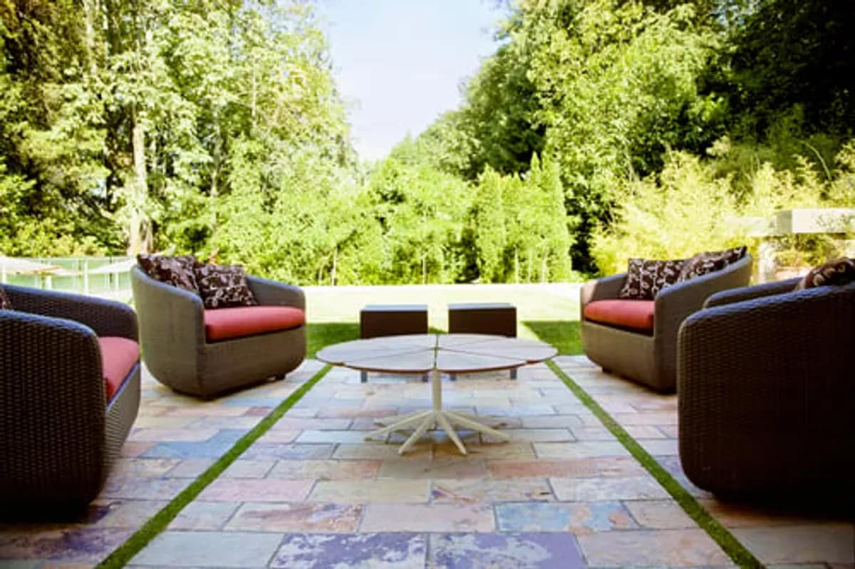 Paver patio with outdoor furniture beside a landscaped garden