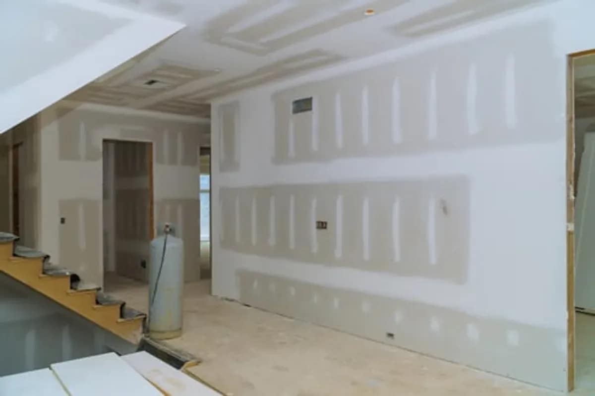 Drywall panels installed and taped in a room under renovation
